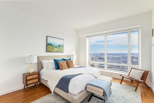 bedroom featuring baseboards and wood finished floors