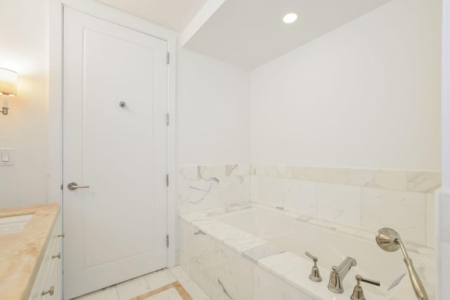 bathroom with vanity, a garden tub, and recessed lighting