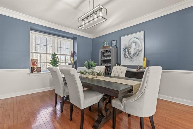 dining space with wood-type flooring and ornamental molding