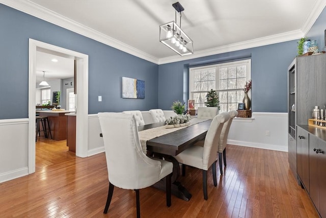 dining room featuring hardwood / wood-style floors and crown molding