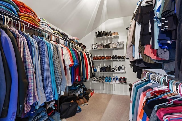 walk in closet featuring carpet floors and vaulted ceiling