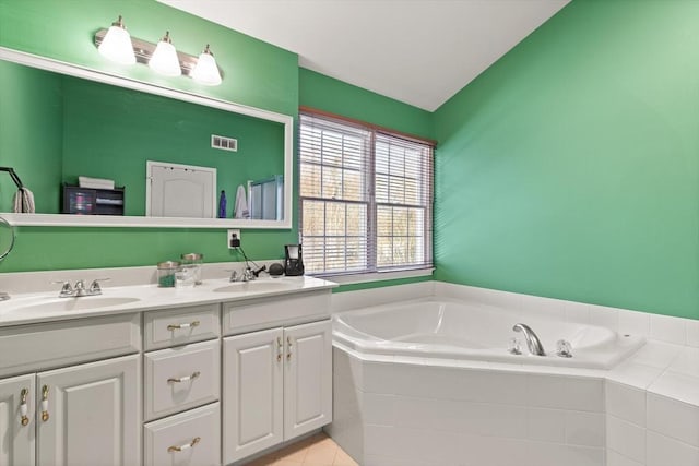 bathroom featuring vanity, tile patterned flooring, a relaxing tiled tub, and lofted ceiling