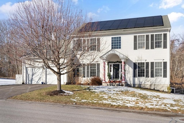 colonial house with a garage and solar panels