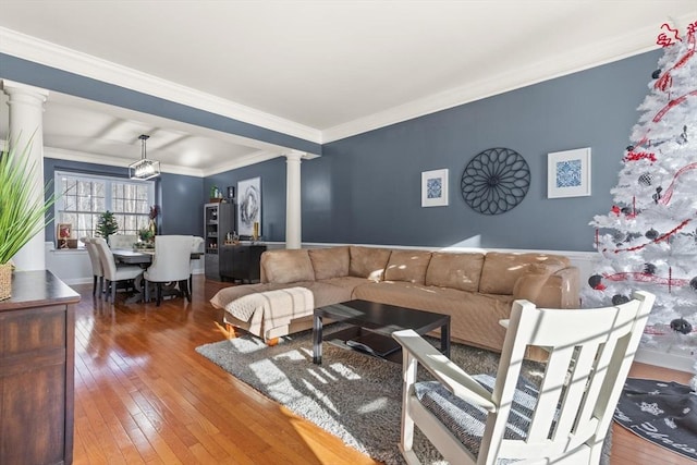 living room with hardwood / wood-style flooring, ornamental molding, and decorative columns