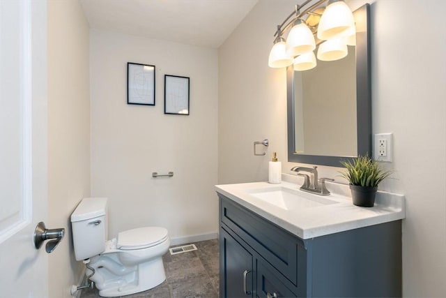 bathroom with an inviting chandelier, vanity, and toilet