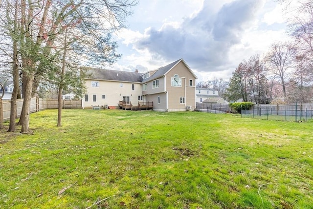 back of property with a lawn and a wooden deck