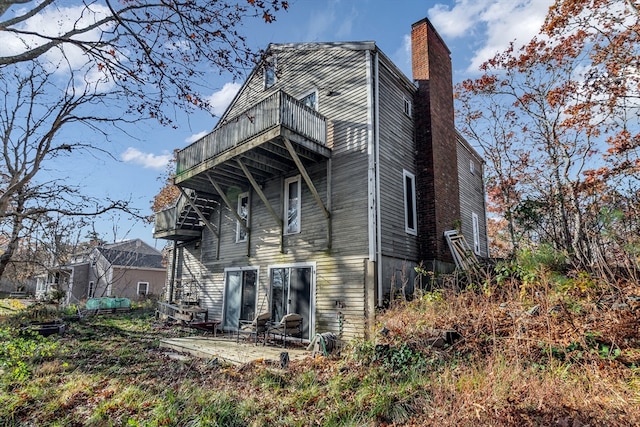 rear view of house featuring a balcony and a patio area