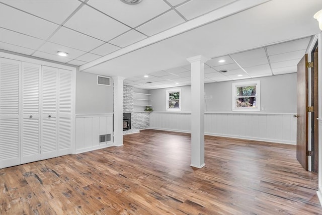 2 Walker St, Norton, MA 02766 - basement featuring a wainscoted wall, wood finished floors, a drop ceiling, a fireplace, and built in shelves