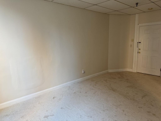 unfurnished room with a paneled ceiling and carpet flooring