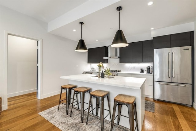 531-533 E 2nd St Unit 202, Boston, MA 02127 - kitchen with high end refrigerator, dark cabinets, light countertops, a sink, and wall chimney range hood