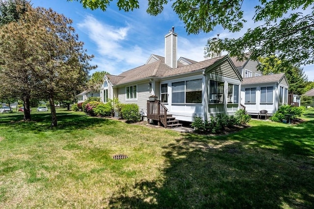 19 Longwood Rd Unit 243, Mashpee, MA 02649 - rear view of house with a sunroom, a yard, a chimney, and roof with shingles