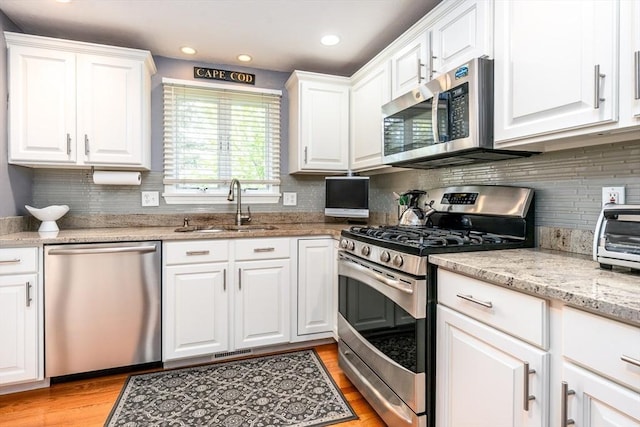 19 Longwood Rd Unit 243, Mashpee, MA 02649 - kitchen featuring stainless steel appliances, a sink, white cabinets, backsplash, and recessed lighting