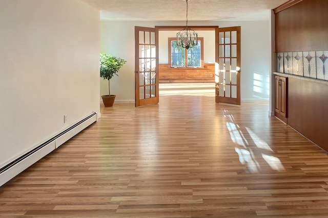 unfurnished dining area with french doors, light hardwood / wood-style floors, and a baseboard radiator