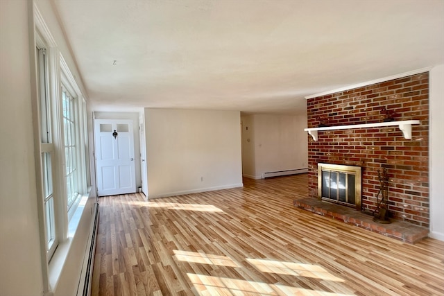 unfurnished living room featuring a fireplace, light hardwood / wood-style floors, and a baseboard heating unit