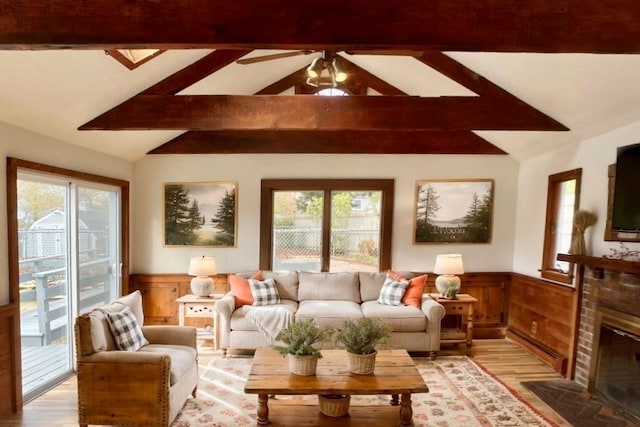 sunroom featuring a brick fireplace, plenty of natural light, vaulted ceiling with beams, and ceiling fan