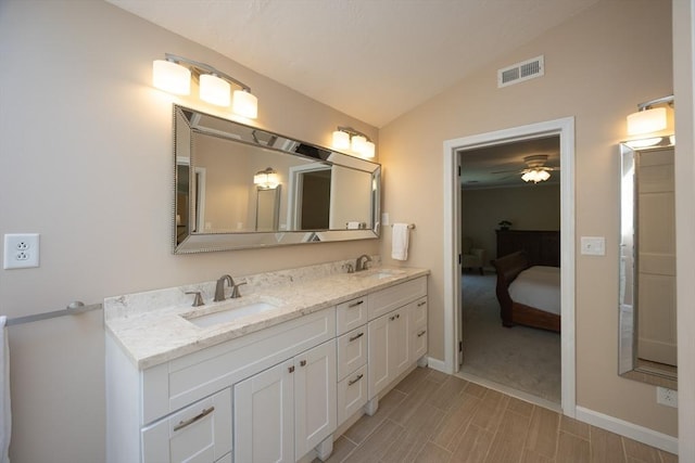13 Valleywood Rd, Hopkinton, MA 01748 - bathroom featuring vaulted ceiling, double vanity, connected bathroom, baseboards, and wood finish floors