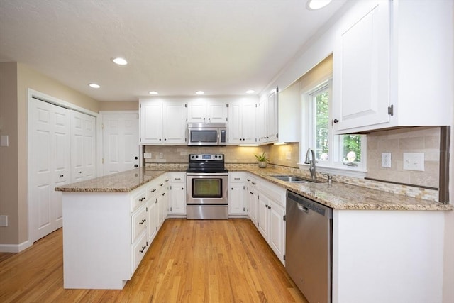 13 Valleywood Rd, Hopkinton, MA 01748 - kitchen with stainless steel appliances, a sink, light wood-style flooring, light stone counters, and white cabinets
