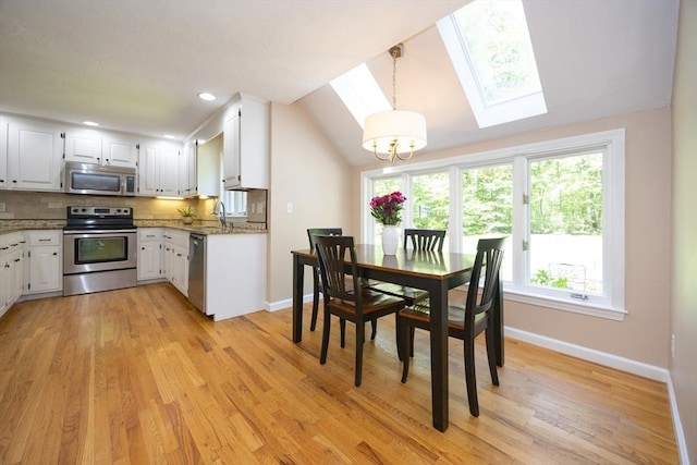 13 Valleywood Rd, Hopkinton, MA 01748 - dining area featuring a skylight, baseboards, light wood-type flooring, a chandelier, and lofted ceiling