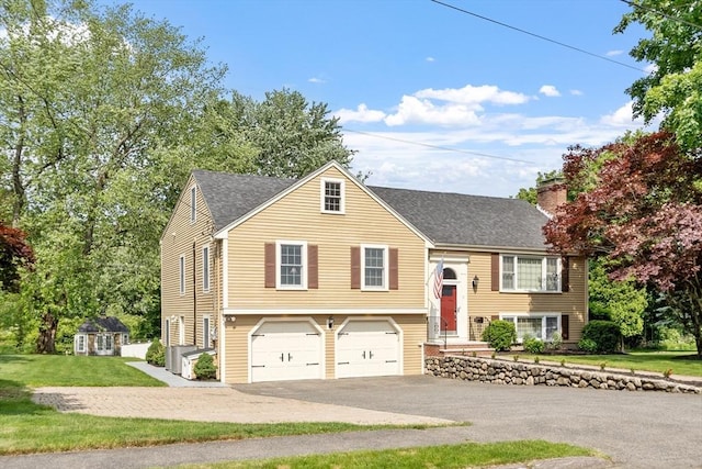 9 New Meadow Rd, Lynnfield, MA 01940 - bi-level home featuring asphalt driveway, a shingled roof, a garage, a front yard, and a chimney