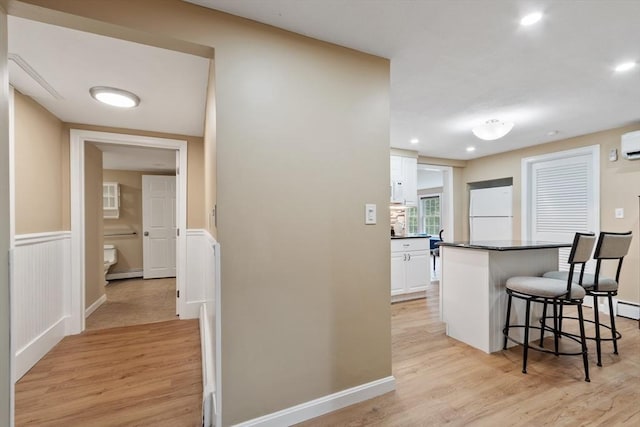 9 New Meadow Rd, Lynnfield, MA 01940 - kitchen featuring freestanding refrigerator, a kitchen bar, white cabinets, dark countertops, and light wood-style flooring