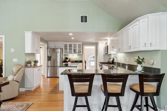 9 New Meadow Rd, Lynnfield, MA 01940 - kitchen with stainless steel appliances, a peninsula, light wood finished floors, a breakfast bar, and white cabinetry