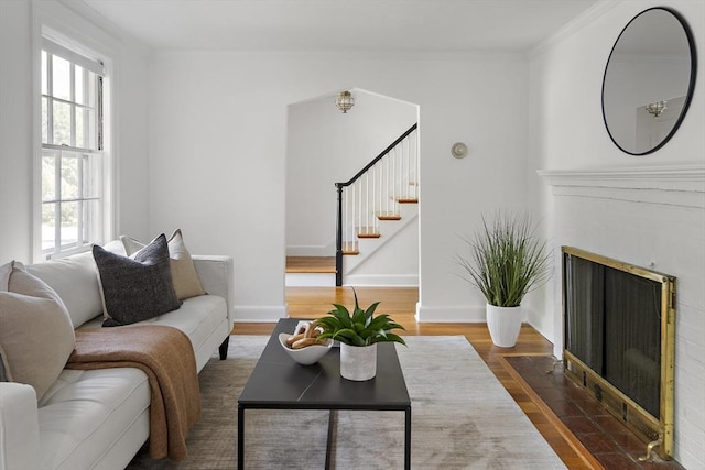 159 Payson Rd, Brookline, MA 02467 - living area featuring healthy amount of natural light, wood finished floors, stairway, a fireplace with flush hearth, and ornamental molding