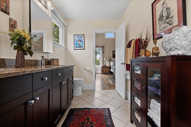 1488 Washington St Unit 1488, Newton, MA 02465 - bathroom with vanity, toilet, tile patterned floors, baseboards, and ensuite bathroom
