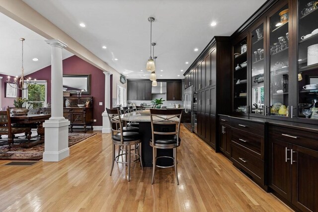 1488 Washington St Unit 1488, Newton, MA 02465 - dining area featuring ornate columns, light wood-style floors, a chandelier, baseboards, and recessed lighting