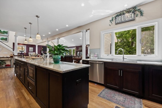1488 Washington St Unit 1488, Newton, MA 02465 - kitchen with stainless steel appliances, ornate columns, a sink, light wood finished floors, and healthy amount of natural light