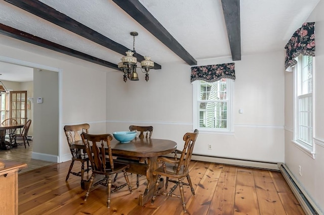 dining area featuring a baseboard heating unit, a chandelier, healthy amount of natural light, wood-type flooring, and beam ceiling