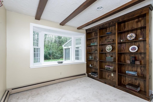 carpeted spare room with baseboard heating, beam ceiling, and a textured ceiling