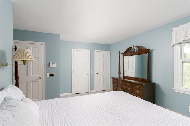 bedroom featuring two closets and baseboards