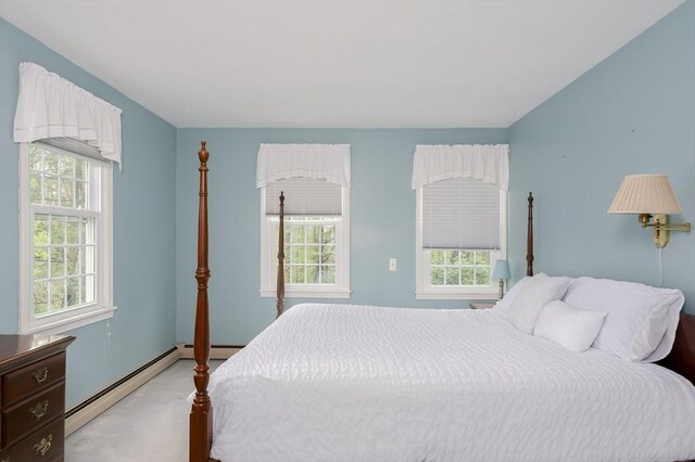 bedroom featuring multiple windows, a baseboard radiator, and baseboards