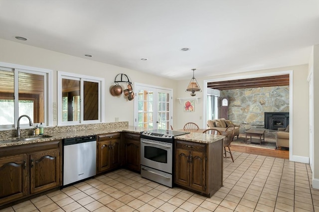 kitchen featuring stainless steel appliances, a sink, healthy amount of natural light, and light tile patterned floors