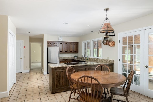 kitchen featuring freestanding refrigerator, french doors, and light tile patterned floors