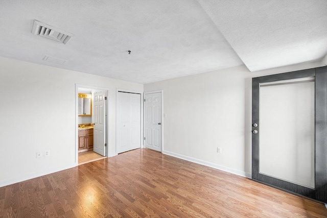 39 Parlin St Unit 503, Everett, MA 02149 - unfurnished bedroom featuring baseboards, light wood-type flooring, connected bathroom, and multiple closets