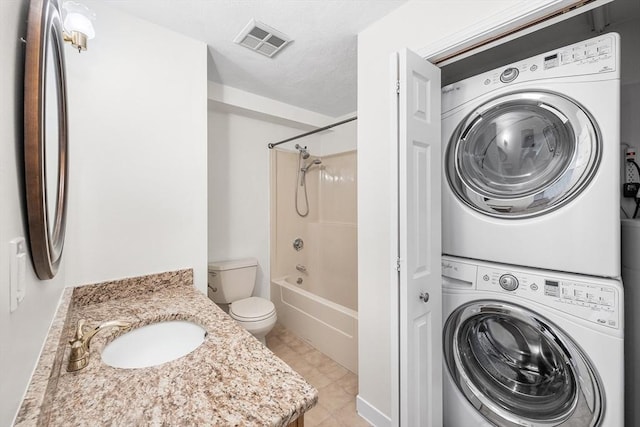 39 Parlin St Unit 503, Everett, MA 02149 - bathroom featuring estacked washer and dryer, toilet, washtub / shower combination, vanity, and tile patterned flooring