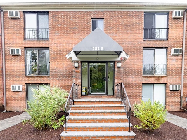 382 Great Rd Unit B 203, Acton, MA 01720 - view of exterior entry with a wall unit AC and brick siding