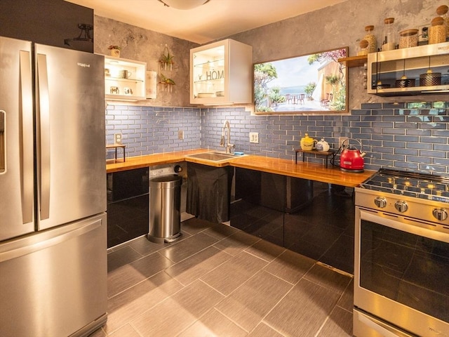 382 Great Rd Unit B 203, Acton, MA 01720 - kitchen with appliances with stainless steel finishes, butcher block countertops, open shelves, a sink, and glass insert cabinets