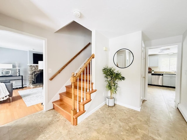 staircase featuring tile patterned flooring, a fireplace, and baseboards