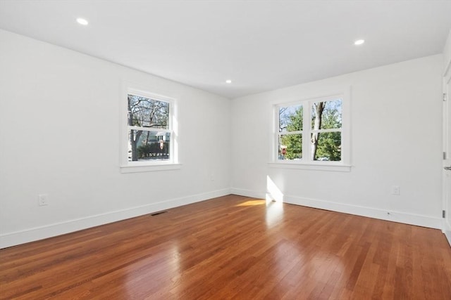 spare room with hardwood / wood-style flooring and plenty of natural light