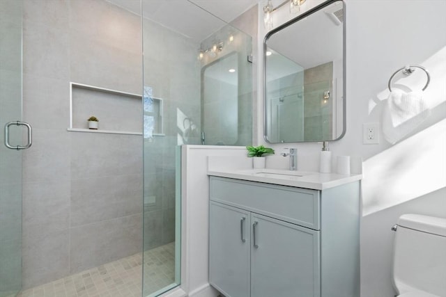 bathroom featuring vanity, toilet, and walk in shower