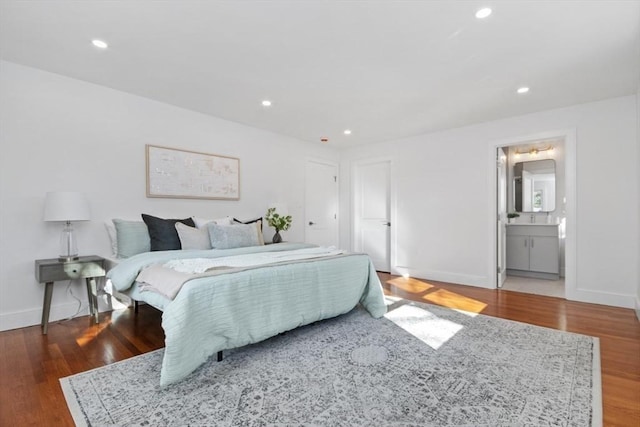 bedroom featuring connected bathroom and hardwood / wood-style flooring