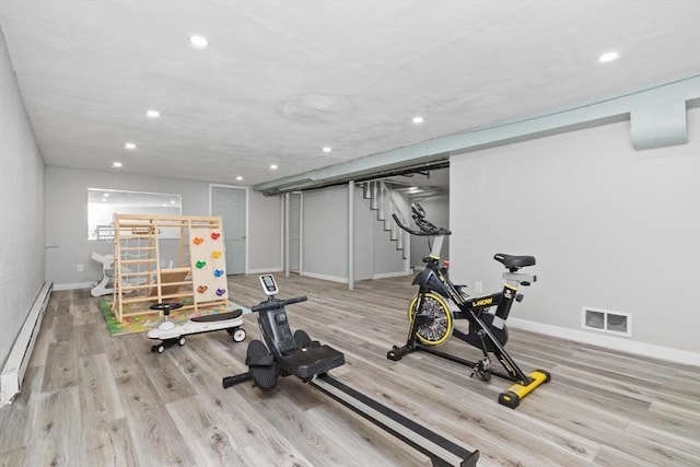 workout room featuring visible vents, a baseboard heating unit, wood finished floors, recessed lighting, and baseboards