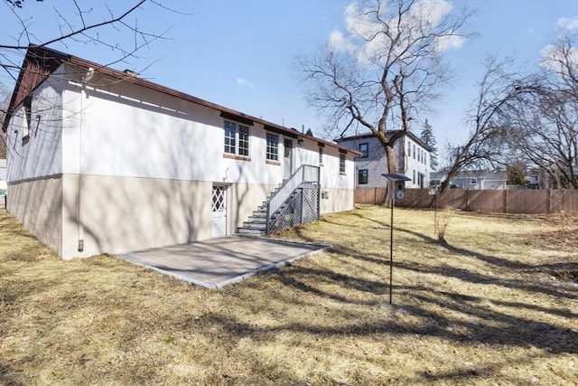 back of property featuring a patio area and fence