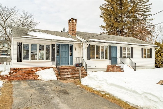 single story home featuring a shingled roof and a chimney