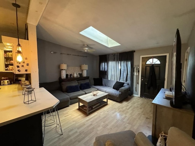 living room with hardwood / wood-style floors, lofted ceiling with skylight, and ceiling fan