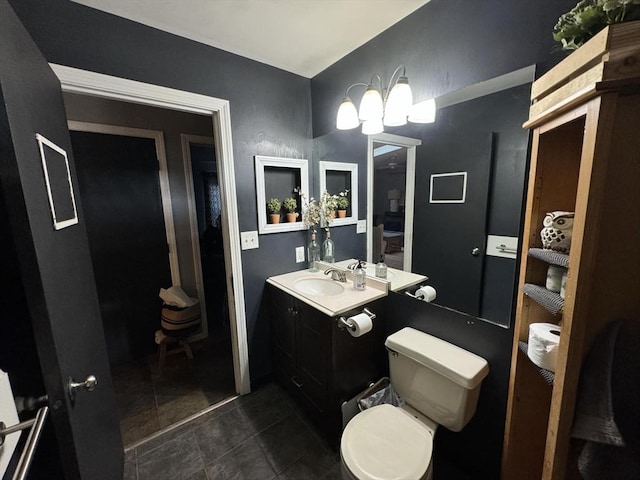 bathroom with toilet, vanity, and tile patterned floors