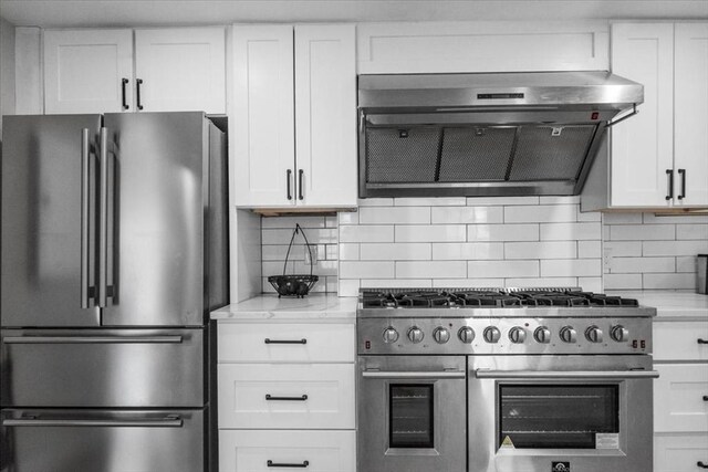 12 Salem St Unit 2, Haverhill, MA 01835 - kitchen with white cabinetry, stainless steel appliances, tasteful backsplash, and exhaust hood