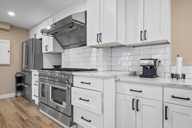 12 Salem St Unit 2, Haverhill, MA 01835 - kitchen featuring white cabinetry, under cabinet range hood, backsplash, and stainless steel appliances